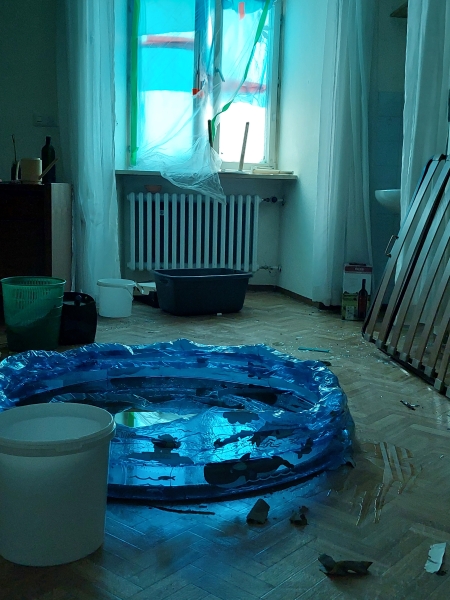 Notdürftig geschützte Fenster und ein Planschbecken, in dem herabtropfendes Wasser aufgefangen wird, im Kloster in Benediktbeuern nach dem Unwetter